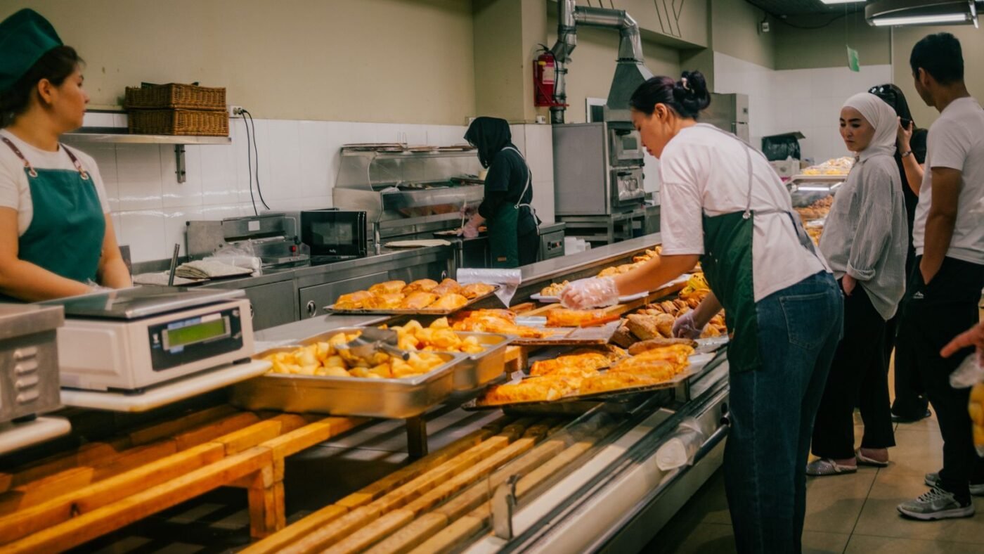 Equipe de padaria trabalhando junta atrás do balcão de pães